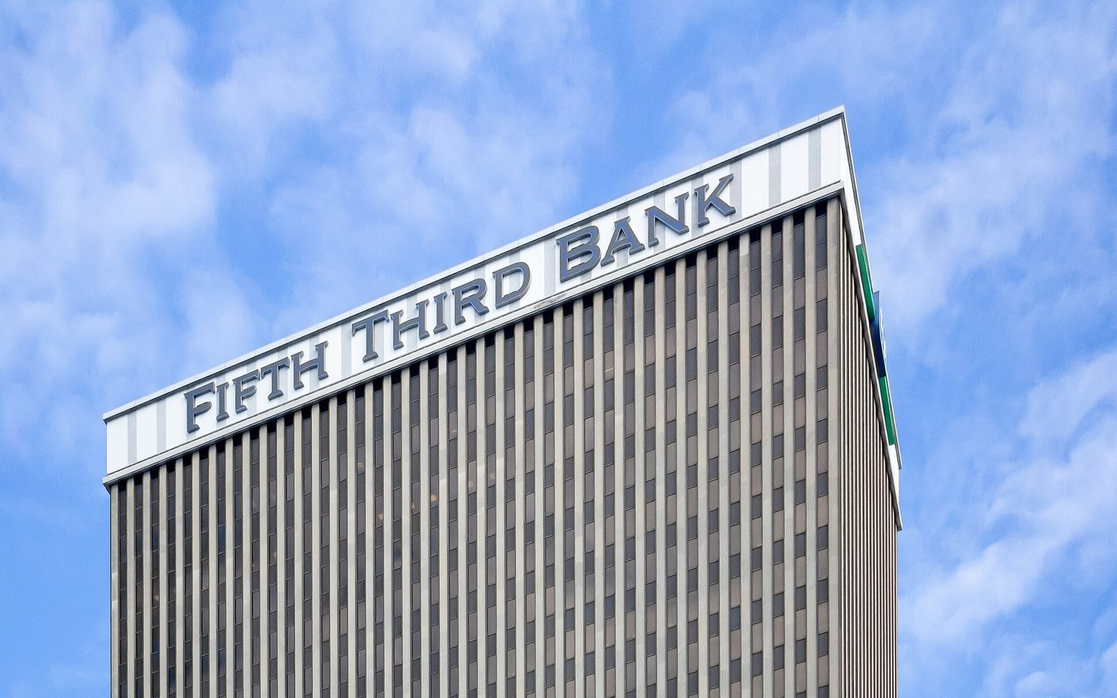 Fifth Third Bank sign atop a high-rise tower against a blue sky