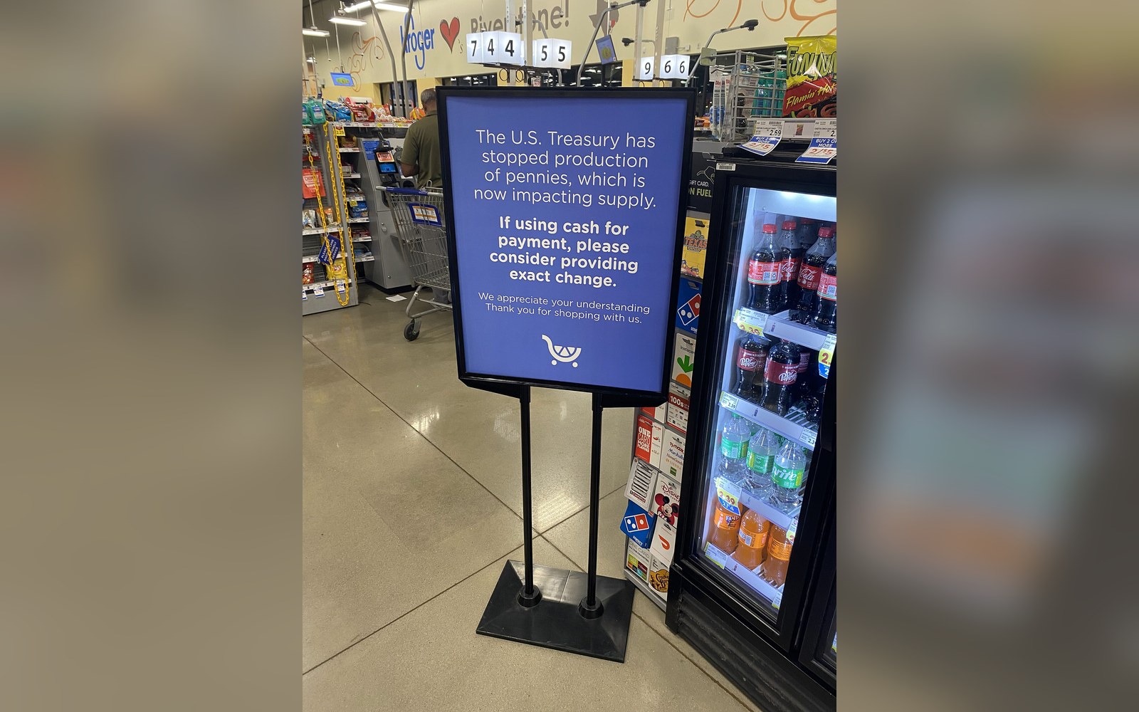 Store sign asking customers to provide exact change due to a penny shortage